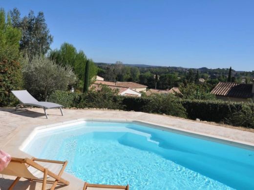 Piscine extérieure privée de la villa à louer en Provence à Paradou, entourée de transats, d'une terrasse en pierre et de végétation méditerranéenne.